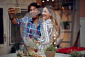 Happy couple posing for a selfie at the open air birthday party. Quality friendship time together