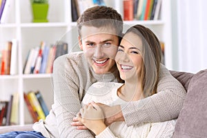 Happy couple posing together on a couch at home