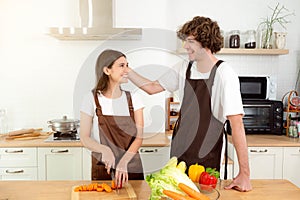 Happy couple preparing food having fun together Man girl standing in kitchen at home