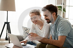 Happy couple purchasing online holding credit card