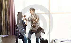 Happy couple arriving in hotel room on holidays