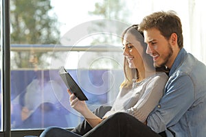 Happy couple reading book on an ebook reader