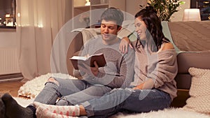 Happy couple reading book at home