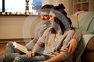 Happy couple reading book at home