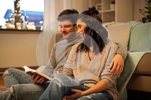 Happy couple reading book at home
