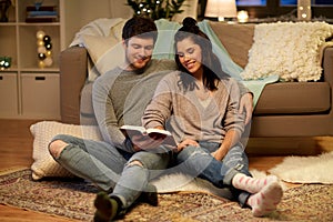 Happy couple reading book at home