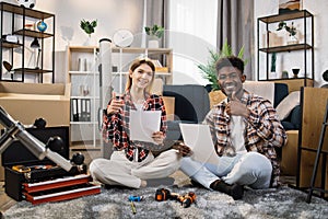 Happy couple reading furniture instruction at new house