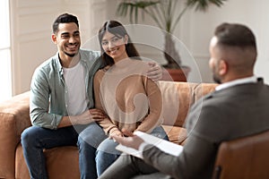 Happy couple reconciling at therapy session with therapists