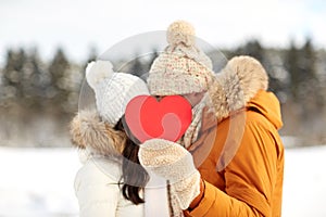 Happy couple with red heart over winter landscape