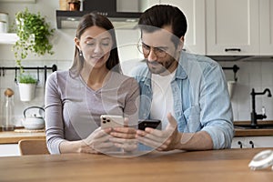 Happy couple relax at home using smartphones