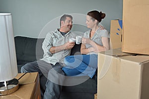 Happy couple relax on a sofa during a move into a new home