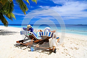 Happy couple relax on a tropical beach photo