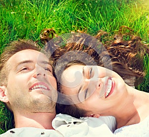 Happy couple relaxing on green grass