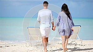 Happy couple relaxing on a tropical beach. Family of two walking together on caribbean