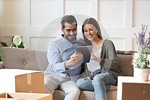 Happy couple renters use tablet on moving day