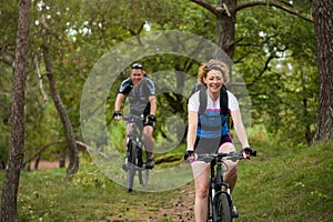 Happy couple riding bicycles outdoors