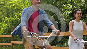 Happy couple riding fixed gear bicycles in summer