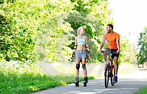 Happy couple with rollerblades and bicycle riding