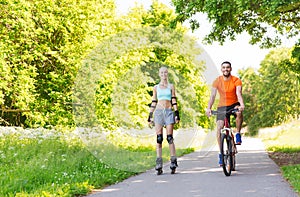 Happy couple with rollerblades and bicycle riding