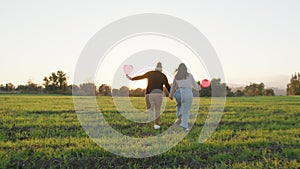 Happy couple run in the meadow to the sun