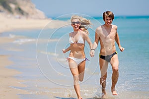 Happy couple running on beach