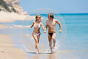 Happy couple running on beach