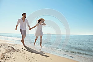 Happy couple running on beach near sea. Honeymoon trip