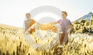 Happy couple running in countryside during spring season - Young lovers having fun together in summer vacation - Travel, love and