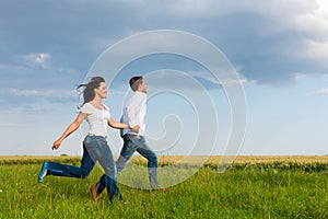 Happy couple running on a dirt road