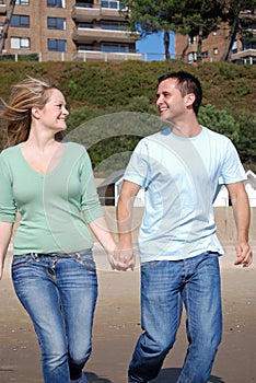 Happy couple running down beach