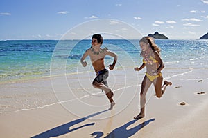 Happy couple running on a hawaii beach