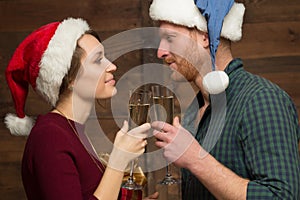 Happy couple in Santa hats with glasses of shampagne
