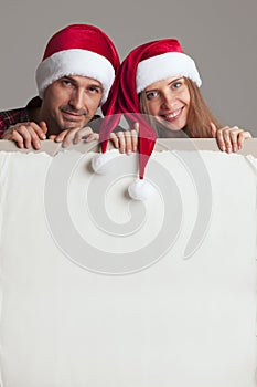 Couple in Santa hats with banner