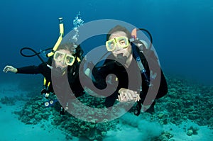 Happy couple scuba dive together