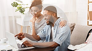 Happy couple searching sightseeings for trip on laptop