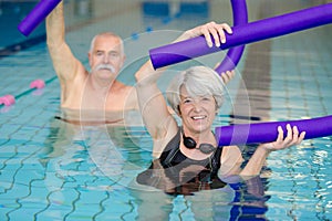 Happy couple seniors enjoying in swimming pool