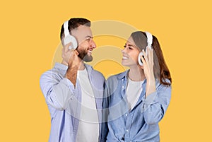 Happy couple sharing music with white headphones