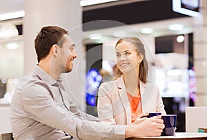 Happy couple with shopping bags drinking coffee