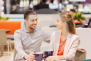 Happy couple with shopping bags drinking coffee