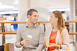 Happy couple with shopping bags drinking coffee