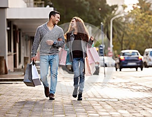 Happy couple, shopping bags and walking in city together for fashion, gift or buying in the outdoors. Man and woman in