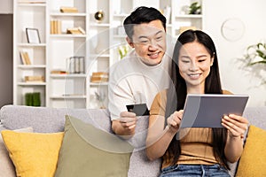 Happy Couple Shopping Online Together on Tablet at Home