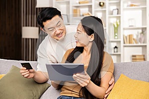 Happy Couple Shopping Online Together on Tablet at Home