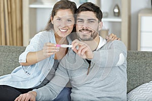 happy couple showing pregnancy test