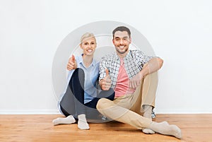 Happy couple showing thumbs up at new home