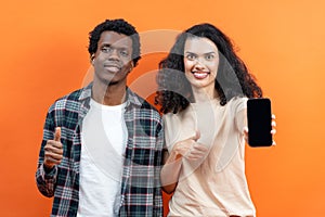 Happy Couple Showing Thumbs Up With Smartphone On Orange Background