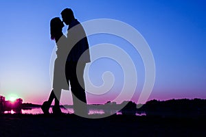 Happy couple silhouette against a sunset romance