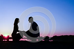 Happy couple silhouette against a sunset romance