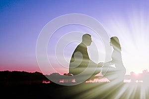 Happy couple silhouette against a sunset romance