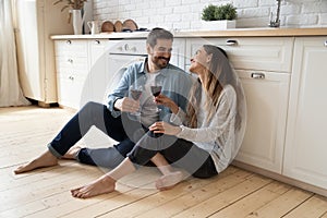 Happy couple sit on floor having romantic date at home